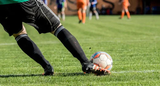 Soccer/Football player on the field about to kick the ball