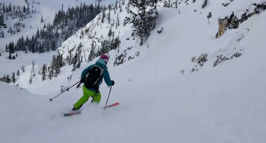 A person skis down a snowy mountain