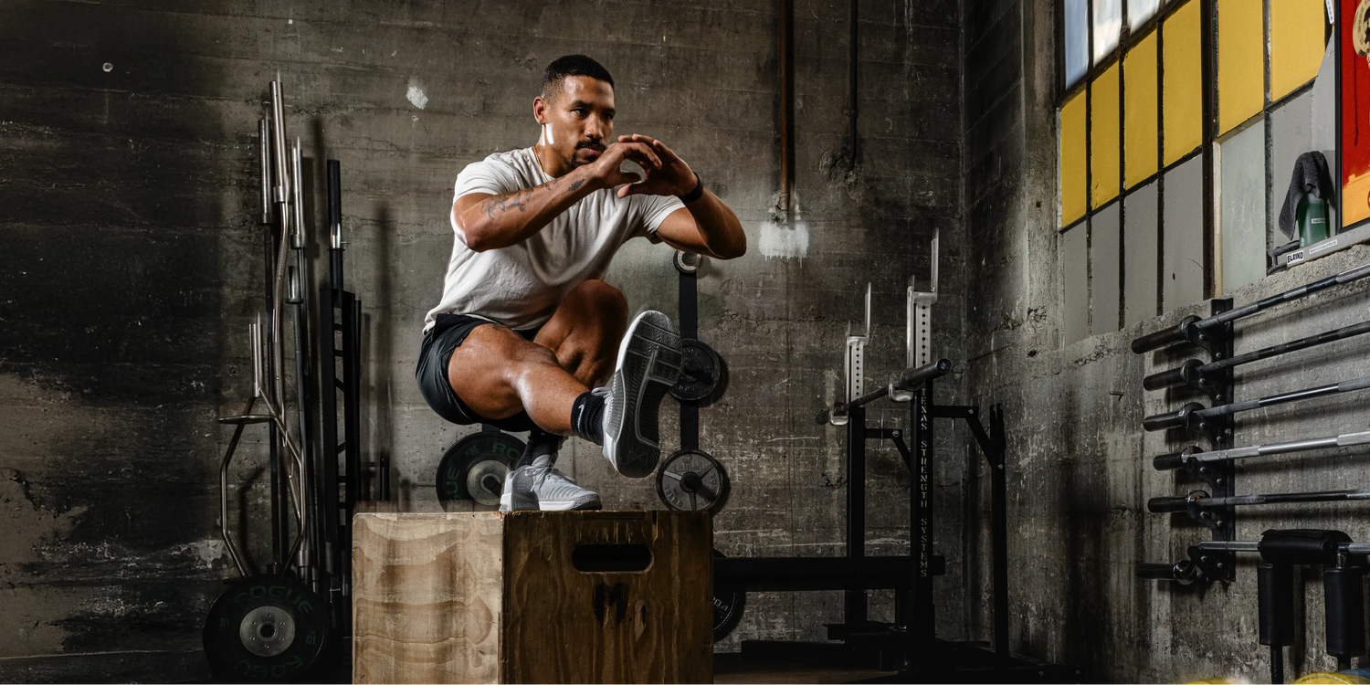 Man in gym doing box squats.