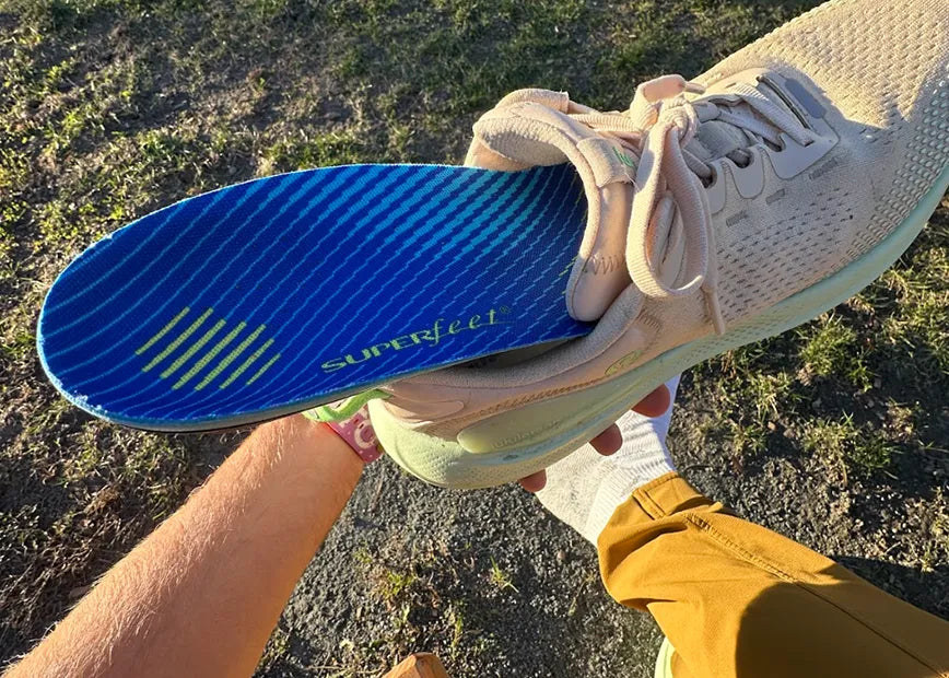 Man holding running show with the Superfeet Run Support Medium Arch insole inside the shoe.