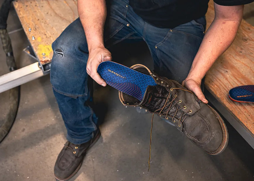 Person putting a work cushion insole in a boot