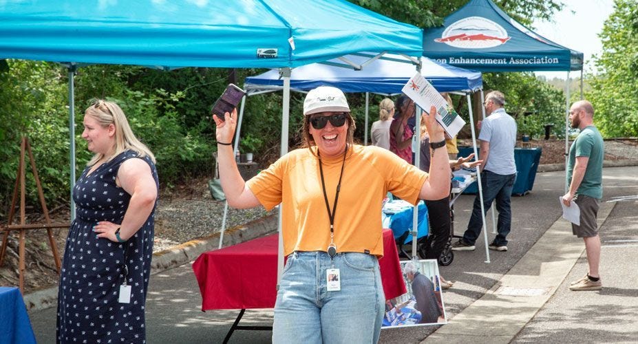 A woman at the Superfeet Giving Fair raises her arms in excitement