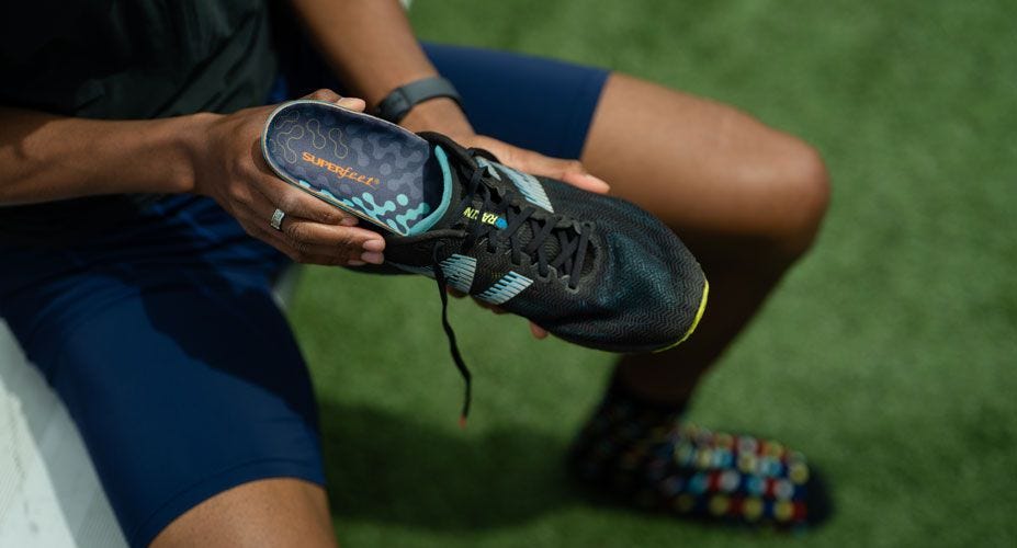 Track athlete puts Superfeet Run Cushion High Arch insoles into his left shoe