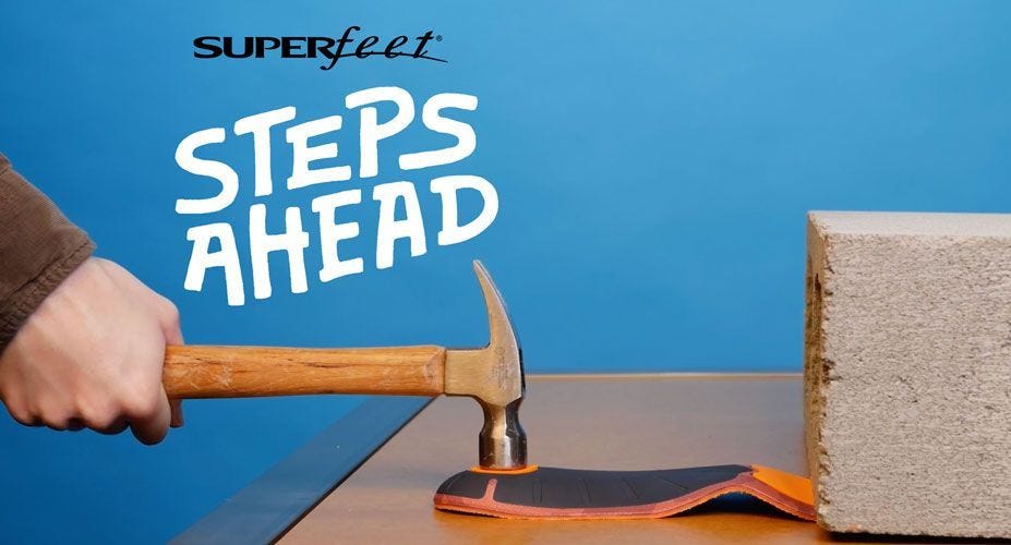 A hand hits the heel of a Superfeet insole with a hammer and the words Superfeet Steps Ahead appear on the image